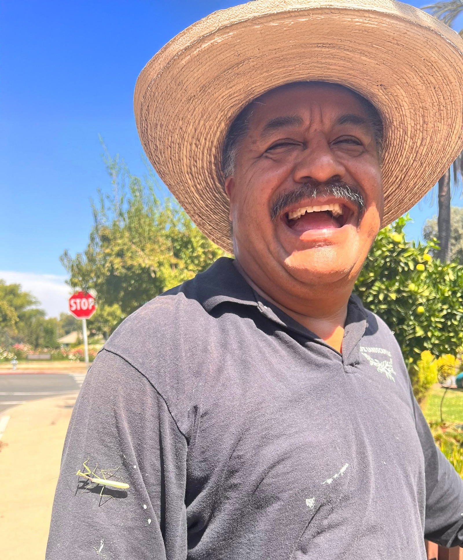 jaun Gardener with praying mantis on his shirt in garden.